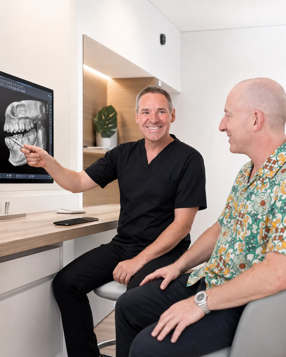 Zahnarzt erkl&auml;rt einem Patienten das R&ouml;ntgenbild, Praxisklinik Dr. Fellmann & Kollegen in Dortmund